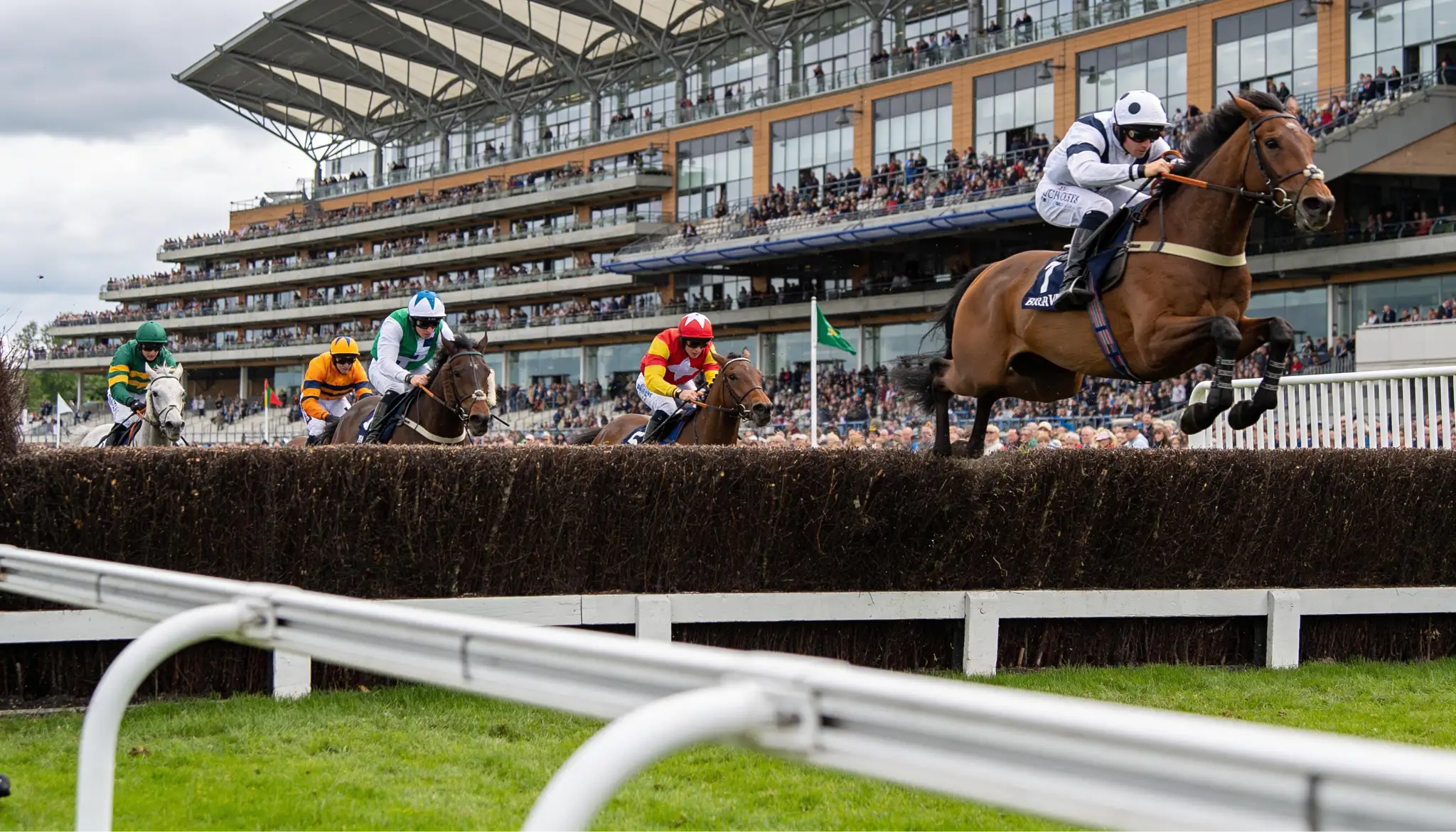 Hindernisrennen beim Grand National in Aintree mit Pferden und Jockeys beim Sprung